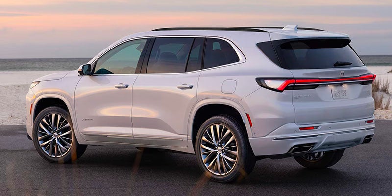 White Buick Enclave SUV viewed from the rear on a coastal road