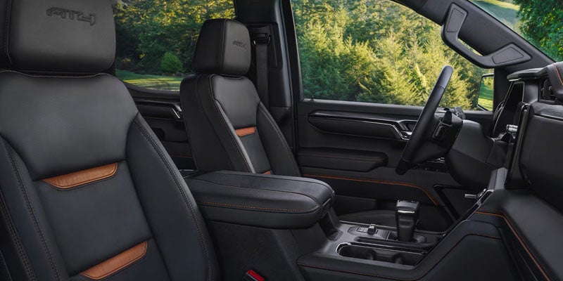 GMC Sierra 1500 interior with black leather front seats, center console, and modern dashboard