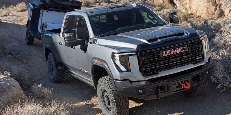 Gray GMC Sierra 2500 HD pickup truck towing a camper