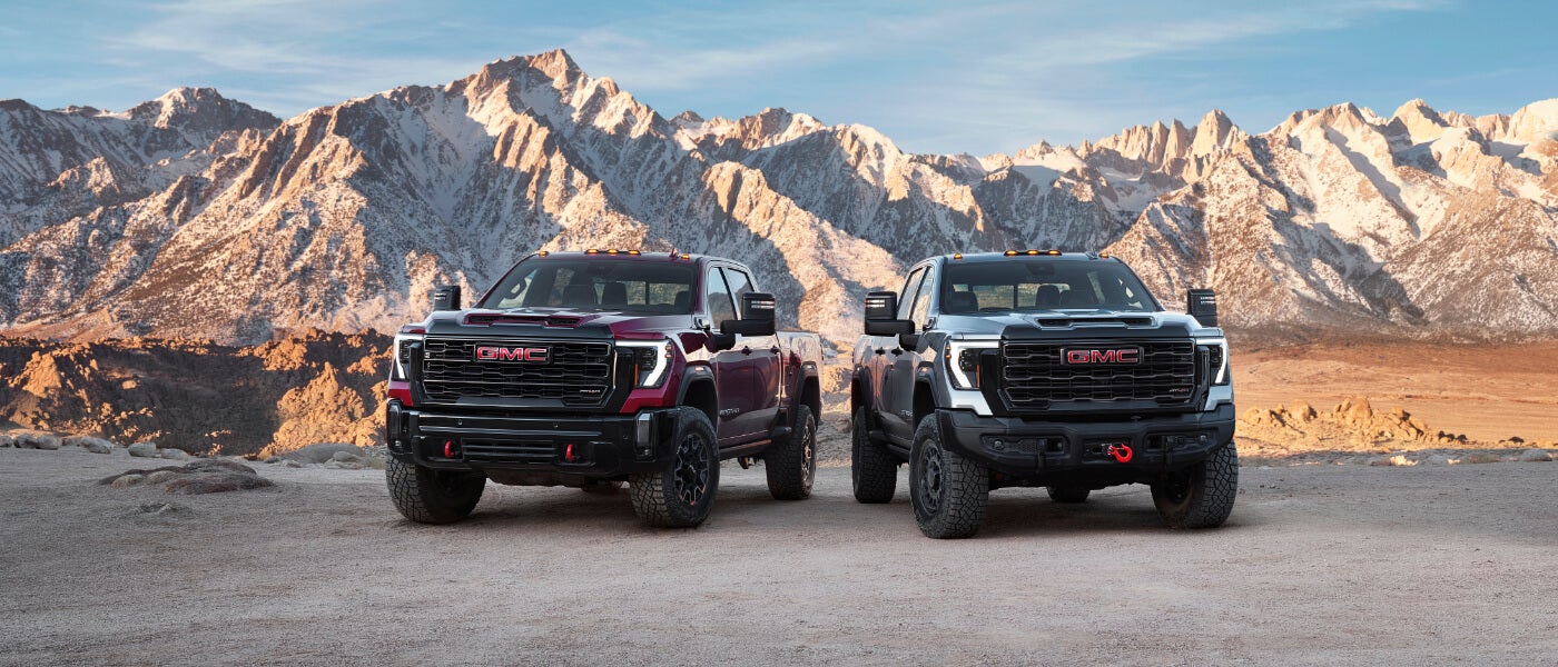 2025 GMC Sierra 2500 HD pair parked in the mountains